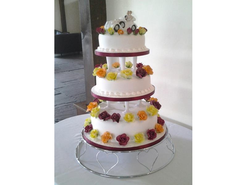 Flowers in claret, orange and yellow colourful wedding cake for pauline's special day at Great Hall of Mains