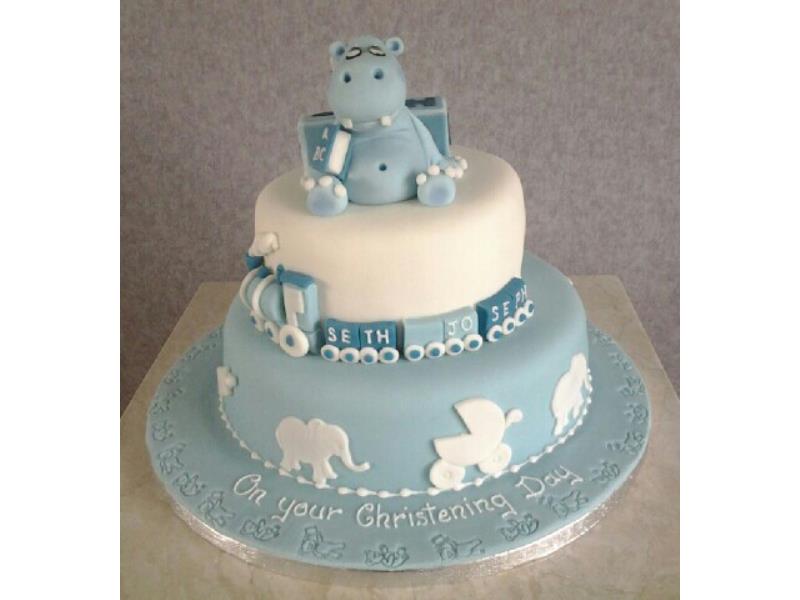 2 tier Chistening cake with elephant and train together with silhouettes. Sponges are lemon and chocolate with orange. For Seth Joseph in Cleveleys.