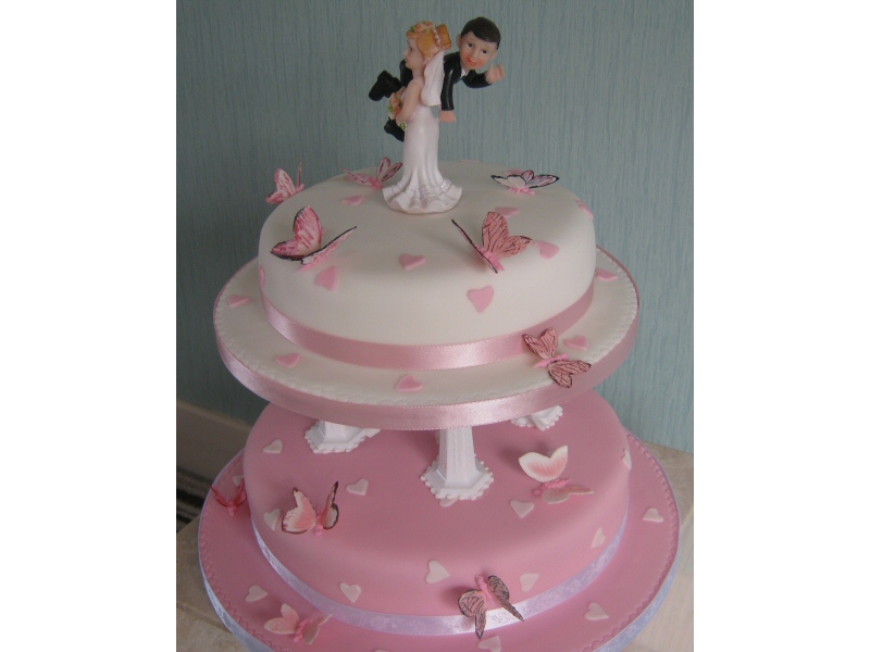 Over The Threshold - Two tier wedding cake with comedy characters for Jennifer and Haydn of Blackpool's wedding at the Ruskin Hotel.